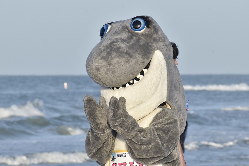 Mote's mascot Gilly applauds racers.