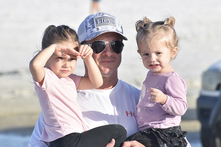Eleanor Spalding, 3, watches the race course for her mother Christina Spalding, with her father Joshua Spalding and sister Maeve Spalding, 1.
