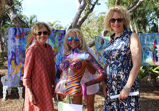 Anne Vose and Jackie Donnelly peruse the works of artist Marie Therese Lacroix, center.