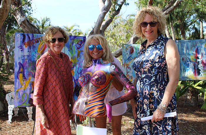 Anne Vose and Jackie Donnelly peruse the works of artist Marie Therese Lacroix, center.
