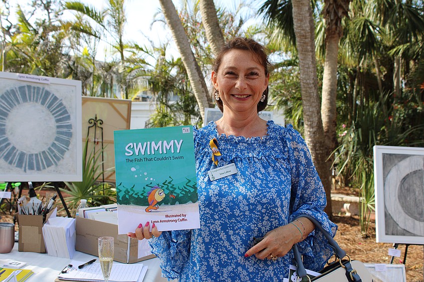 Irina LaRose picks up a copy of the children's book 