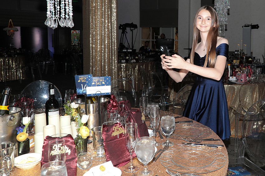 Volunteer social media manager Maggie Rogers grabs some tabletop shots before guests arrive at the Fairytale Ball.