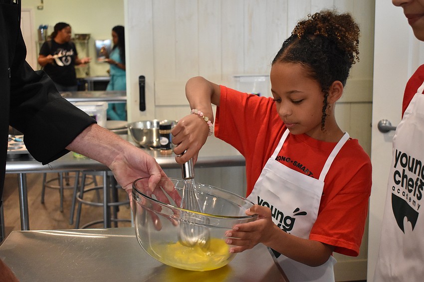 Gloria, a fourth grader, beats an egg.