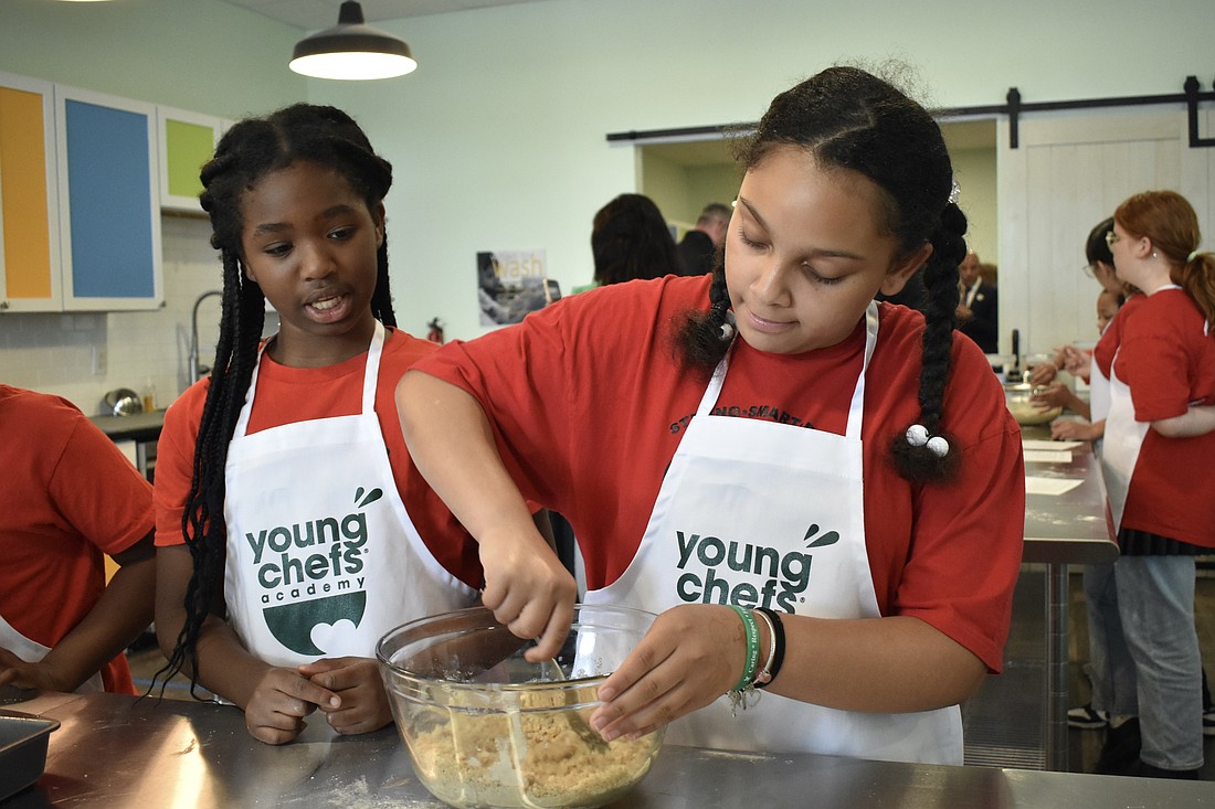 Fifth graders Jaleeyah and Journee mix the coffee cake.