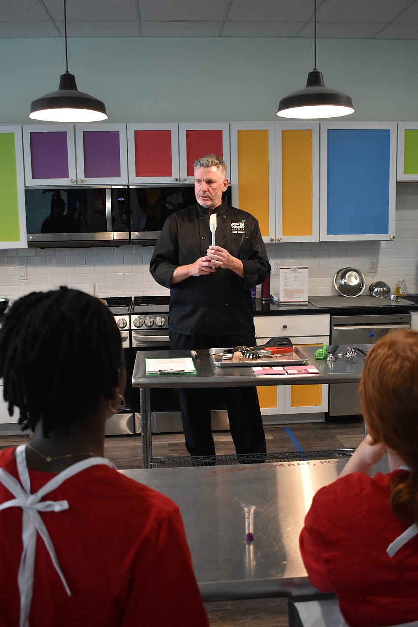 Dennis O'Sullivan, owner of Young Chefs Academy, demonstrates the uses of different kitchen tools.