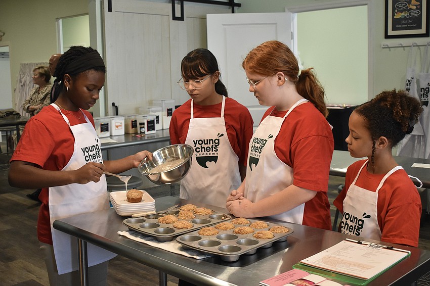 Sixth graders Emma, Arianny and Meadow, and fourth grader Gloria, add icing to the coffee cakes.