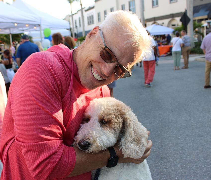Lakewood Ranch's Michael Minik hugs his golden doodle, Chelsea, during the Block Party and Club Day.