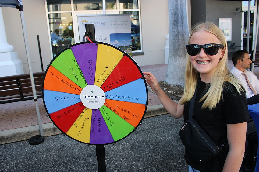 Hannah Swonger spins the Lakewood Ranch Community Foundation's wheel of fortune during the Block Party and Club Day.