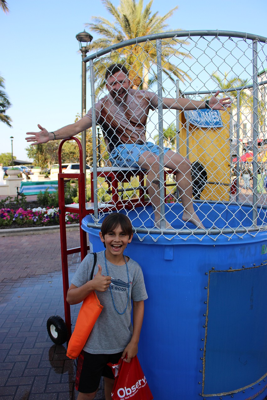 Wayne Parrish of the Lakewood Ranch Business Alliance, gives Lakewood Ranch's Asher Levi credit for throwing a ball, hitting the target and dunking him during the Block Party and Club Day.