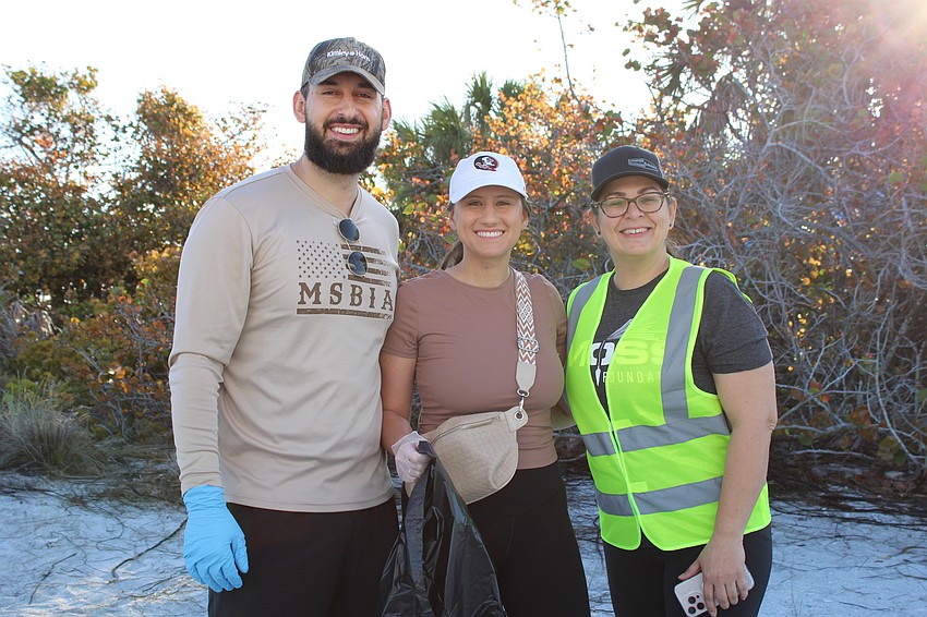 Andrew and Susan Pluta and Vanessa Oliveira help coordinate the Lido Beach cleanup, part of a wider cleanup effort throughout Sarasota County that took place Saturday.
