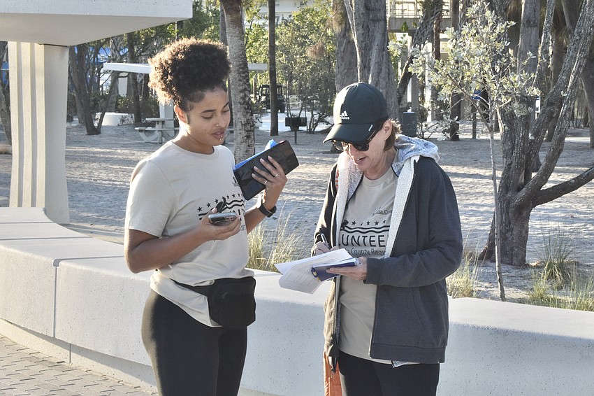 Serena Thompson signs in with help from Penny Long.