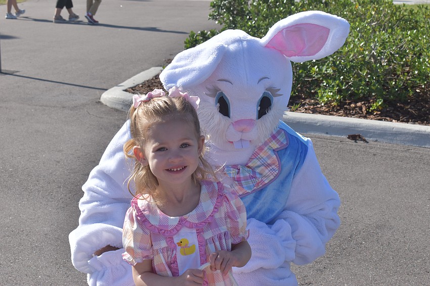 Sophia White, 2, compares matching outfits with the Easter Bunny at Eggstravaganza.