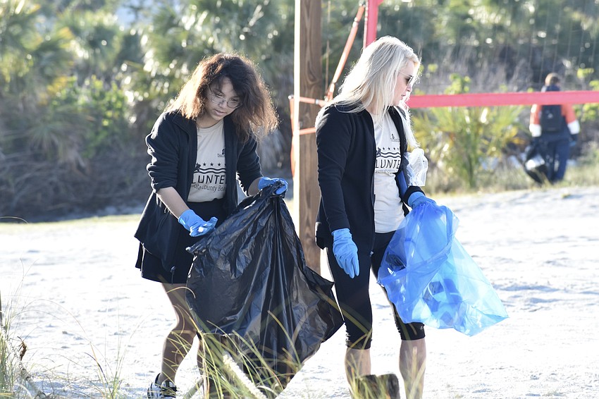 Reagan Sturtevant picks up trash with her mother Alicia MacFarlane.