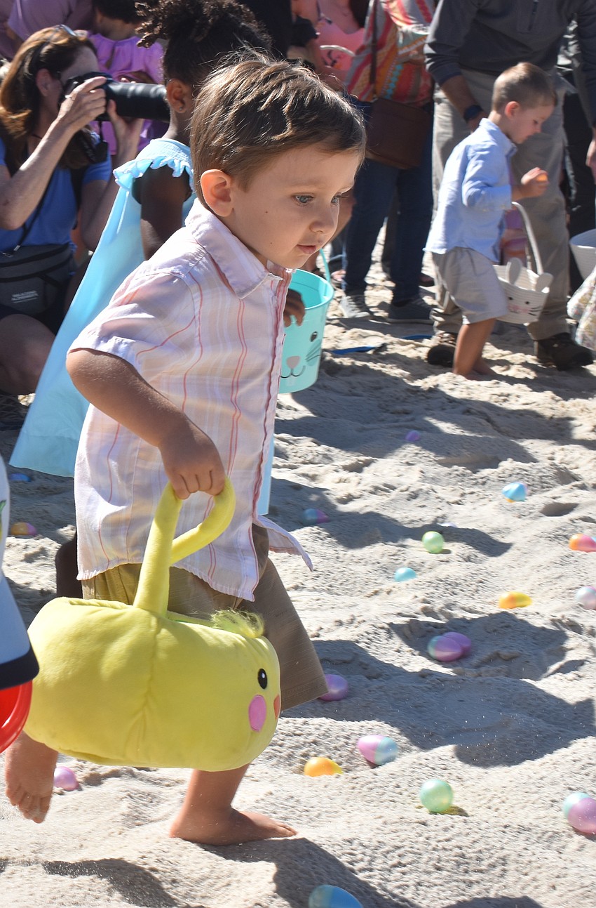 Francois Einwaechter, 3, gets his toes in the sand as he collects eggs during Eggstravaganza at Waterside Park.