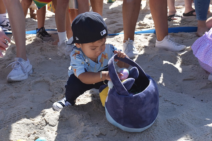 Liam Carbajal, 1, wears a Bluey shirt as he checks his eggs in his Bluey basket.