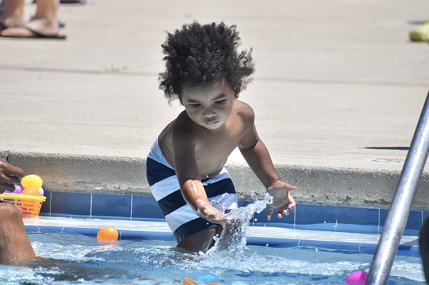 Onyx Robinson, 2, splashes in the water.
