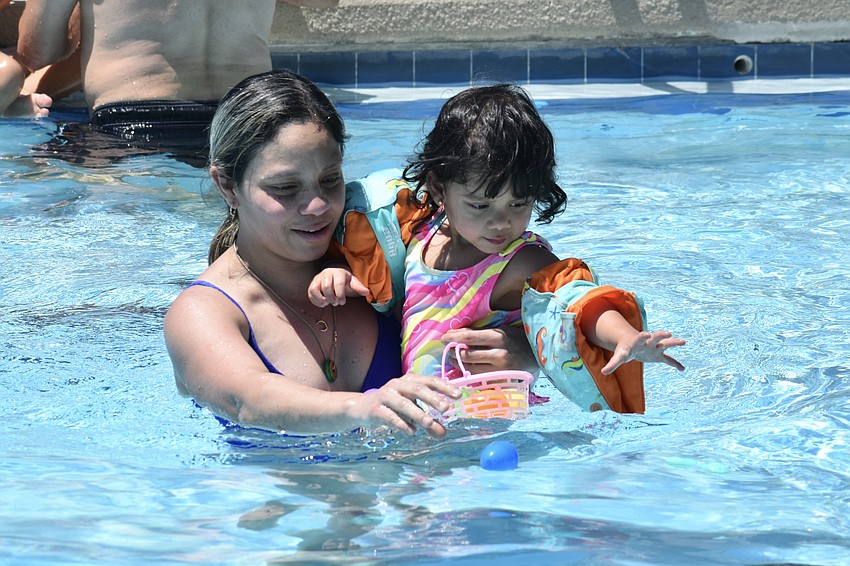 Dorelys Rios and Ashley Ochoa, 2, hunt for eggs.