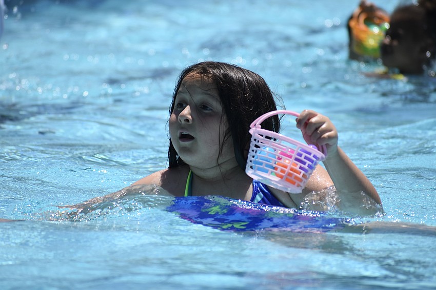 McKenzie Galvan, 8, searches the pool for eggs.