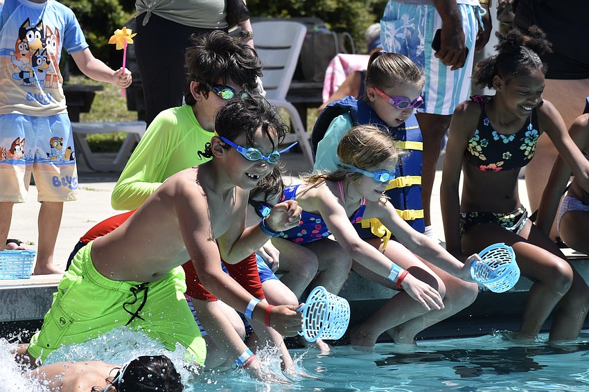 Kids dive into the pool during the deep water egg hunt.