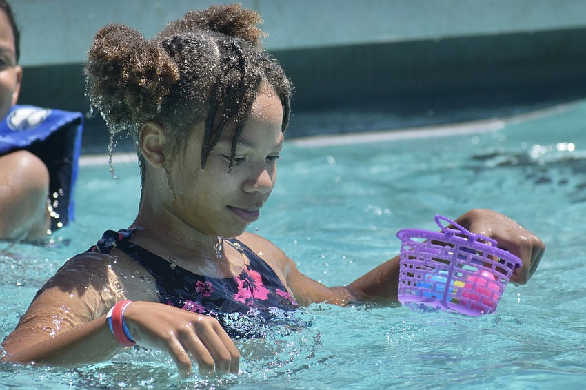 Ameliah Gaskalla, 11, fills a basket with eggs.