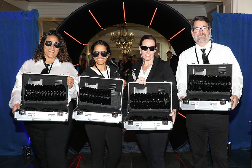 As guests enter the Mission Pawssible event at the Ritz they collect black shades from Amy Fulton, Yasmeen Malik, Pamela Parrino and Chris Fulton.