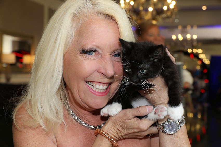 Elizabeth Olguin snuggles with an irresistible kitten at the Mission Pawssible luncheon on April 11.