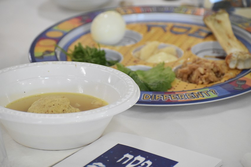 Matzo ball soup and the Seder plate are set out on a table.