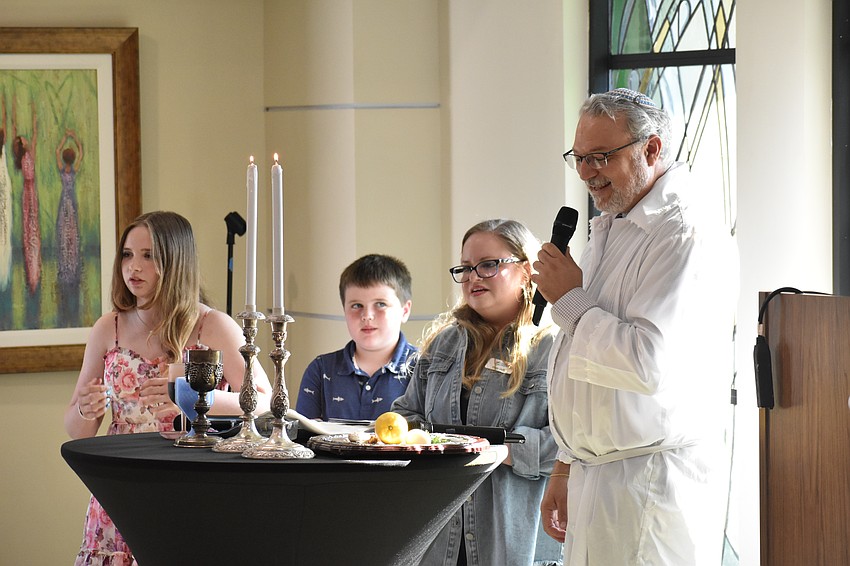 Alana Duffy, 13, Nolan Duffy, 11 and their mother Emily Duffy joined Rabbi Michael Shefrin for the lighting of the candles.