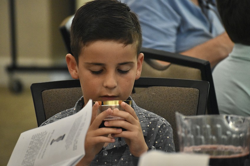 Levi Schwartz, 9, holds the wine as it is blessed.