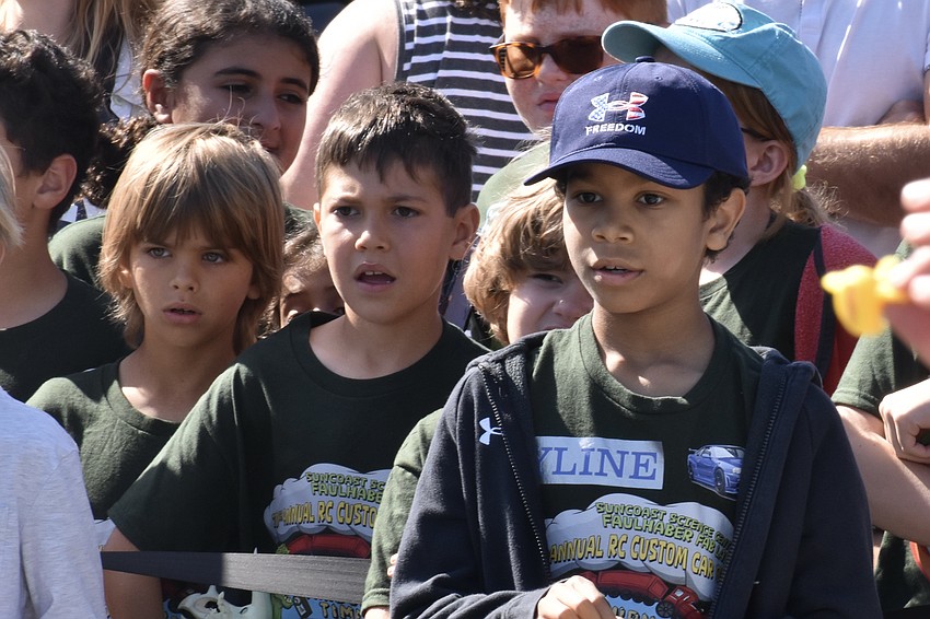 Nick Riesz, Michael Pershin and Luke Kunkel watch as Kunkel steers his car through the course of the drag race.