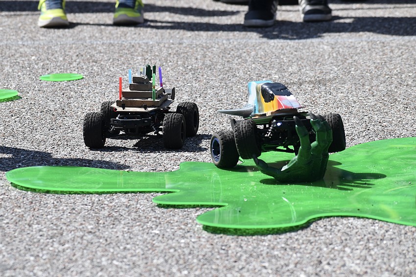 Cars begin racing across the drag race course.
