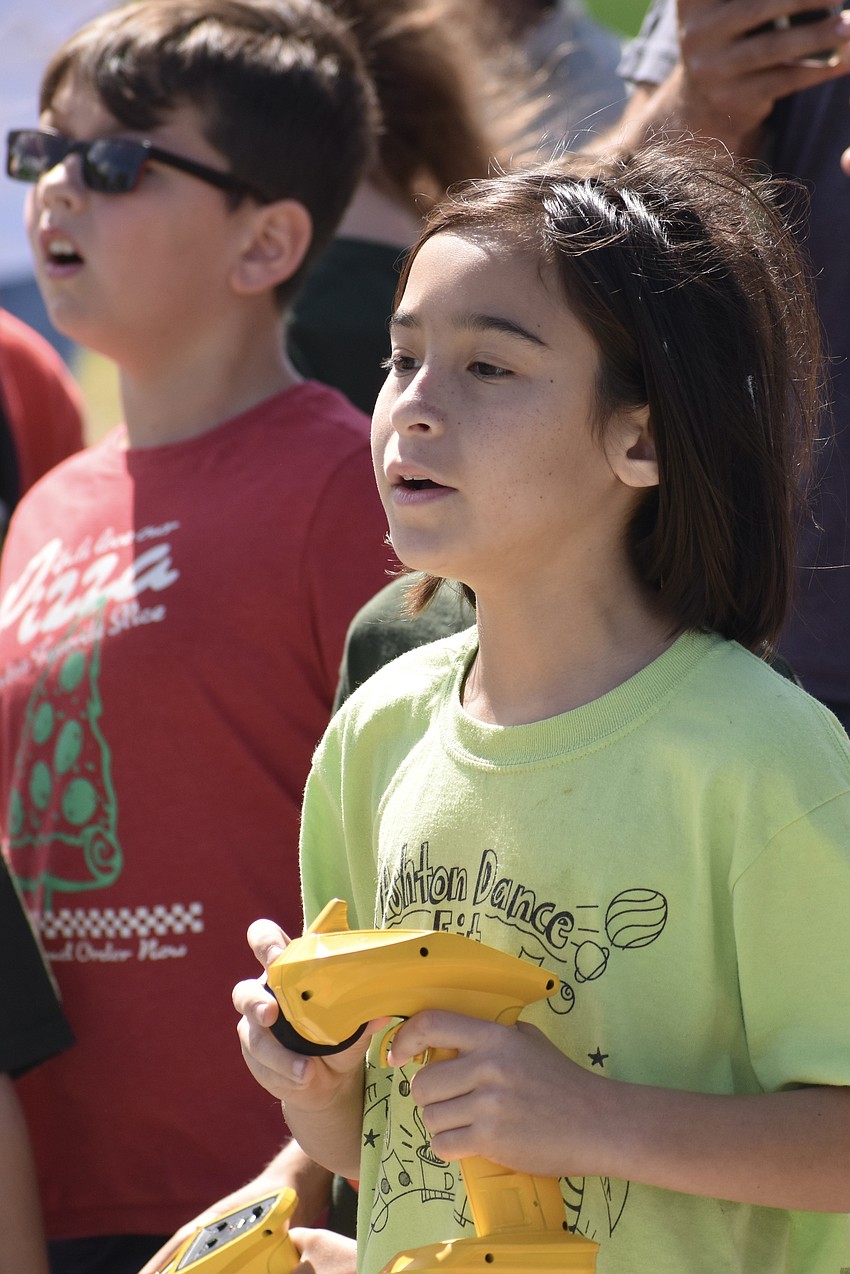 Evan Gray watches the race as Logan Chow controls one of the cars.
