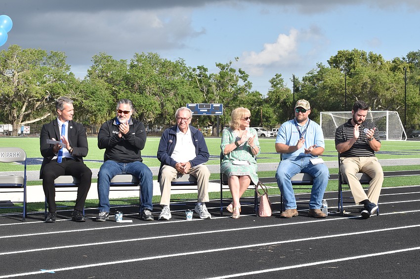 Superintendent of Schools Terry Connor, County Commissioner Joe Neunder, Jon Swift of Jon F. Swift Construction, School Board Member Robyn Marinelli, Jon. F. Swift Construction Vice President Justin Williams, and Principal Sean Donovan applaud the opening of the new track.