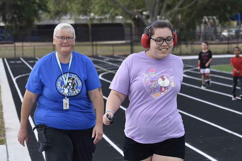 Instructor Marcy Russell walks with 12th grader Jillian Humphreys.
