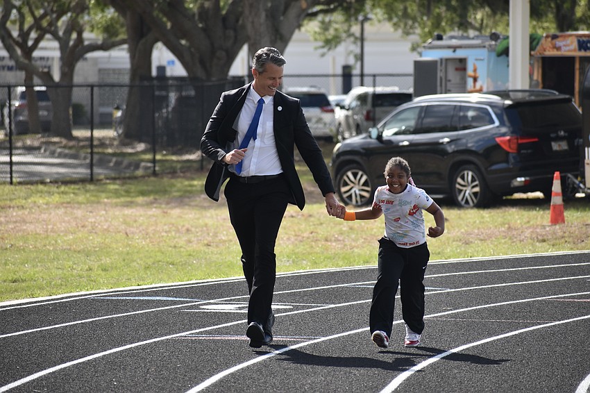Superintendent of Schools Terry Connor runs with Sage Robinson of the Kindergarten to second grade classroom.