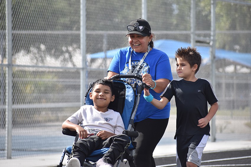 Iker Gomez-Jara of the Kindergarten to second grade classroom, instructor Lisbeth Zurita, and Jayden Cook walk together.