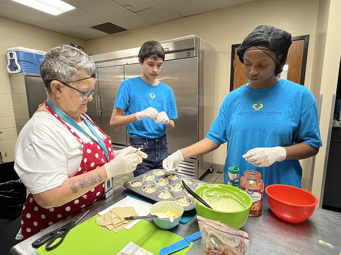 Karen Wise, a teacher at Pathways for Life Academy, taught students Alejandro Resto and Nya Joseph how to make lasagna. Every Friday, students make lunch for everyone in the school.