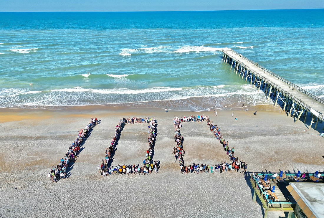 Members of the Rotary Club of Flagler Beach formed a 100 on the pier. From Flagler Beach TV Facebook page