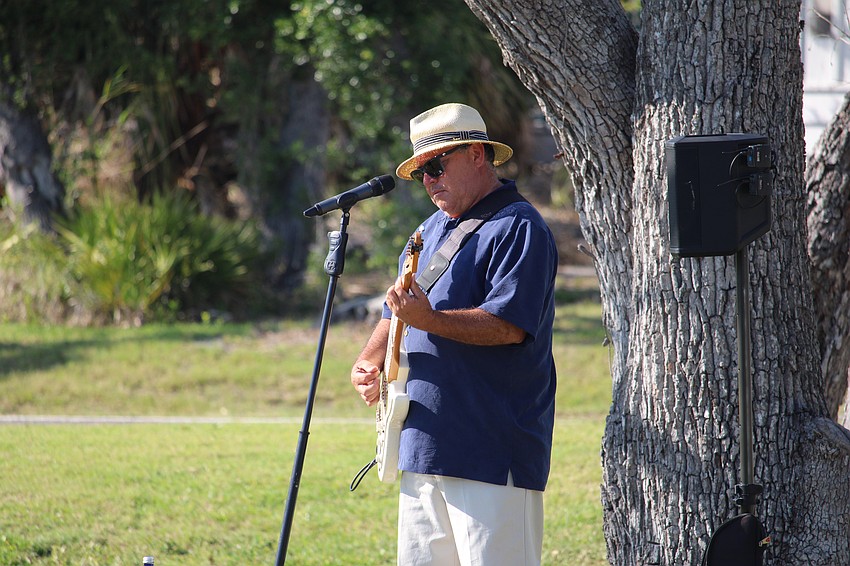 Musician Tim Michael McCaig plays as attendees make their way to the Comedy Night fundraiser.