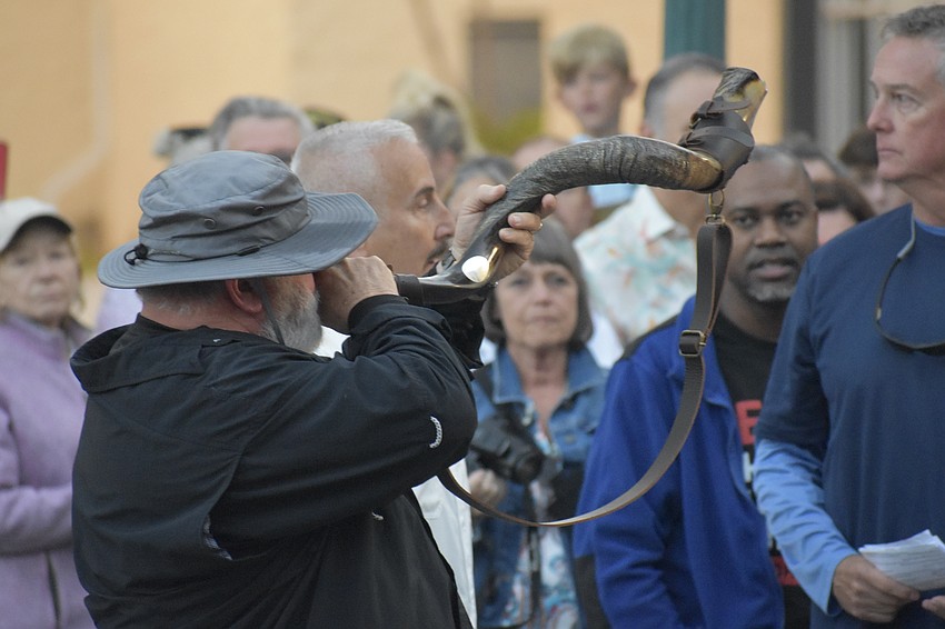 Stephen DeHart, an ordained minister, blows the shofar. 