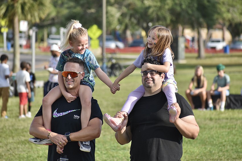 Michael Graf and his daughter Stassia Graf, 6, stands beside Ian Homsi and his daughter Kalila Homsi, 6, as Tim Tebow speaks.
