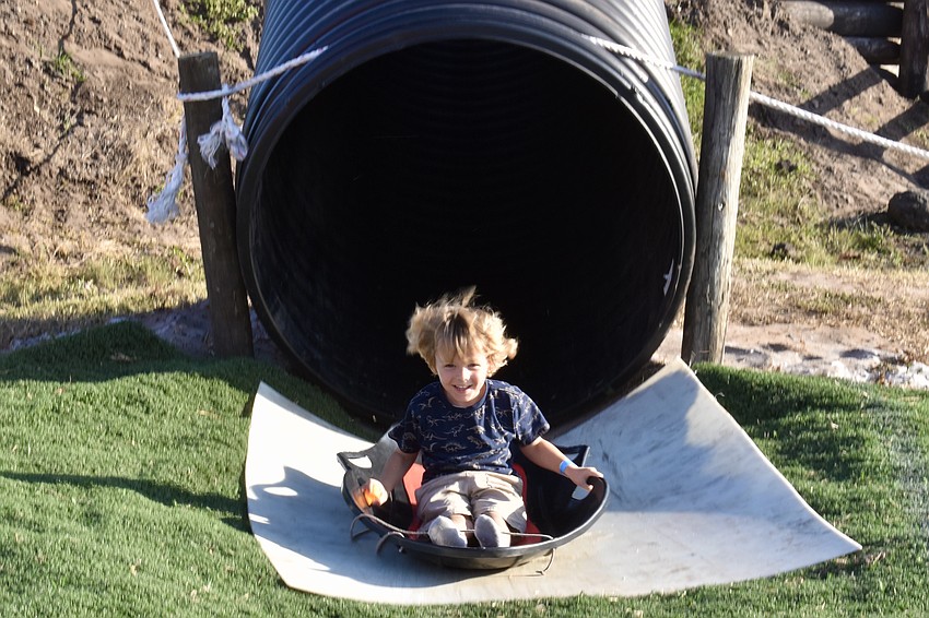 Venice's 4-year-old Alexander Langer exits the slide smiling, despite his hesitancy to enter the dark tunnel at the top of the hill.