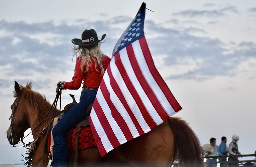 The American flag flies on horseback during the National Anthem at the Dakin Bull Bash.
