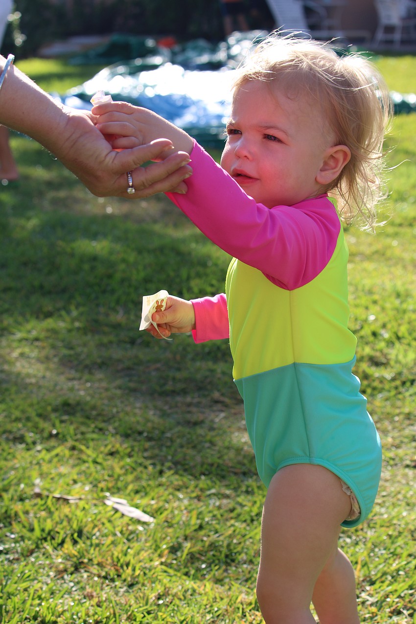 Gianna McKenna, 1.5 years old, shares the stickers she found in an Easter egg at Sand Cay's festivities.
