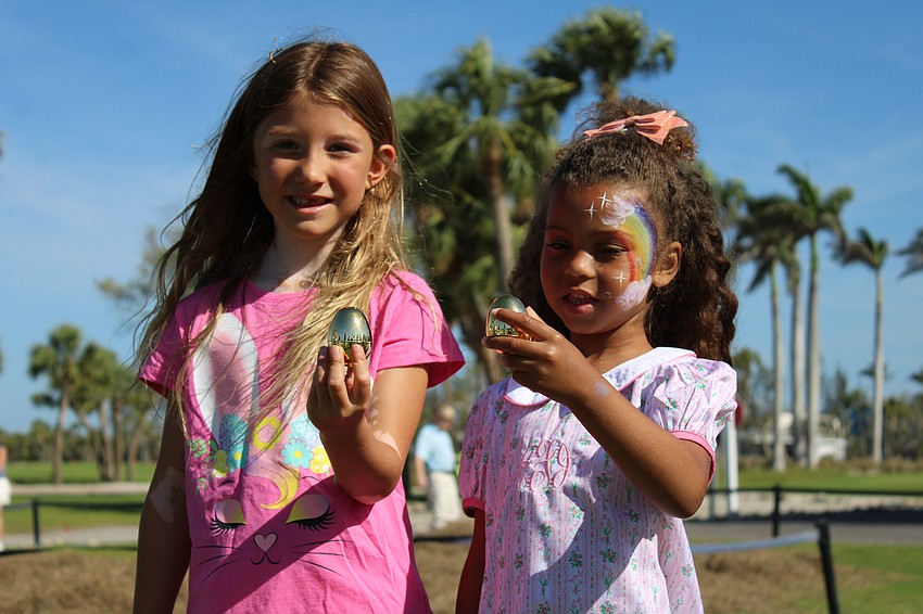 Aspen Fontenot and Callie Schroeyens hold up the golden eggs they uncovered at the Longboat Key Club Resort Easter egg hunt.