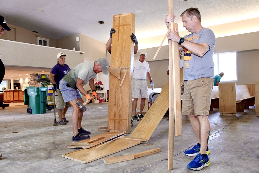 Bob Mazuruk joins the volunteers helping to replace the damaged pews at Longboat Island Chapel on April 22.