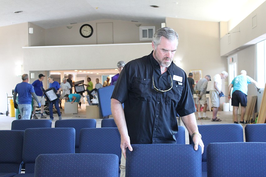 Rev. Brock Patterson arranges the new chairs at Longboat Island Chapel.