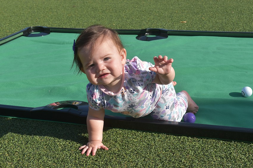 Palm Aire 10-month-old Addie Carney-Debord crawls to the next game at the UTC Kids Club.