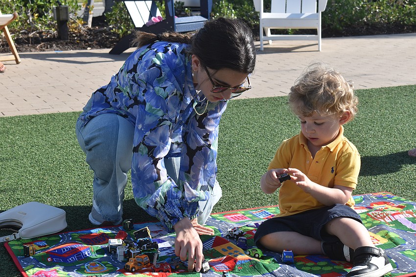 Diala Budeir and her nephew 2-year-old Faris Akel examine and compare cars together on The Green.