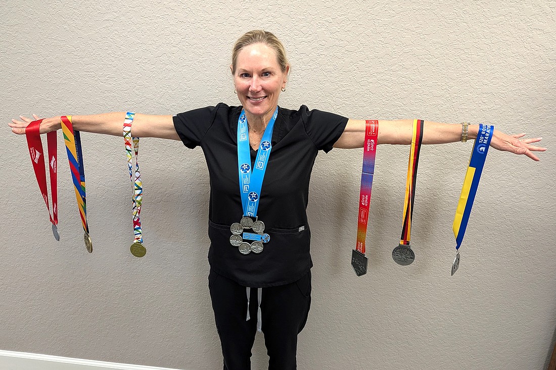 Jessie Bech displays her six major world marathon medals and Six Star Finisher Medal. Photo by Brent Woronoff